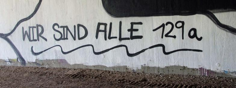 graue hauswand auf welche mit schwarz wir sind alle 129 a geschrieben wurde