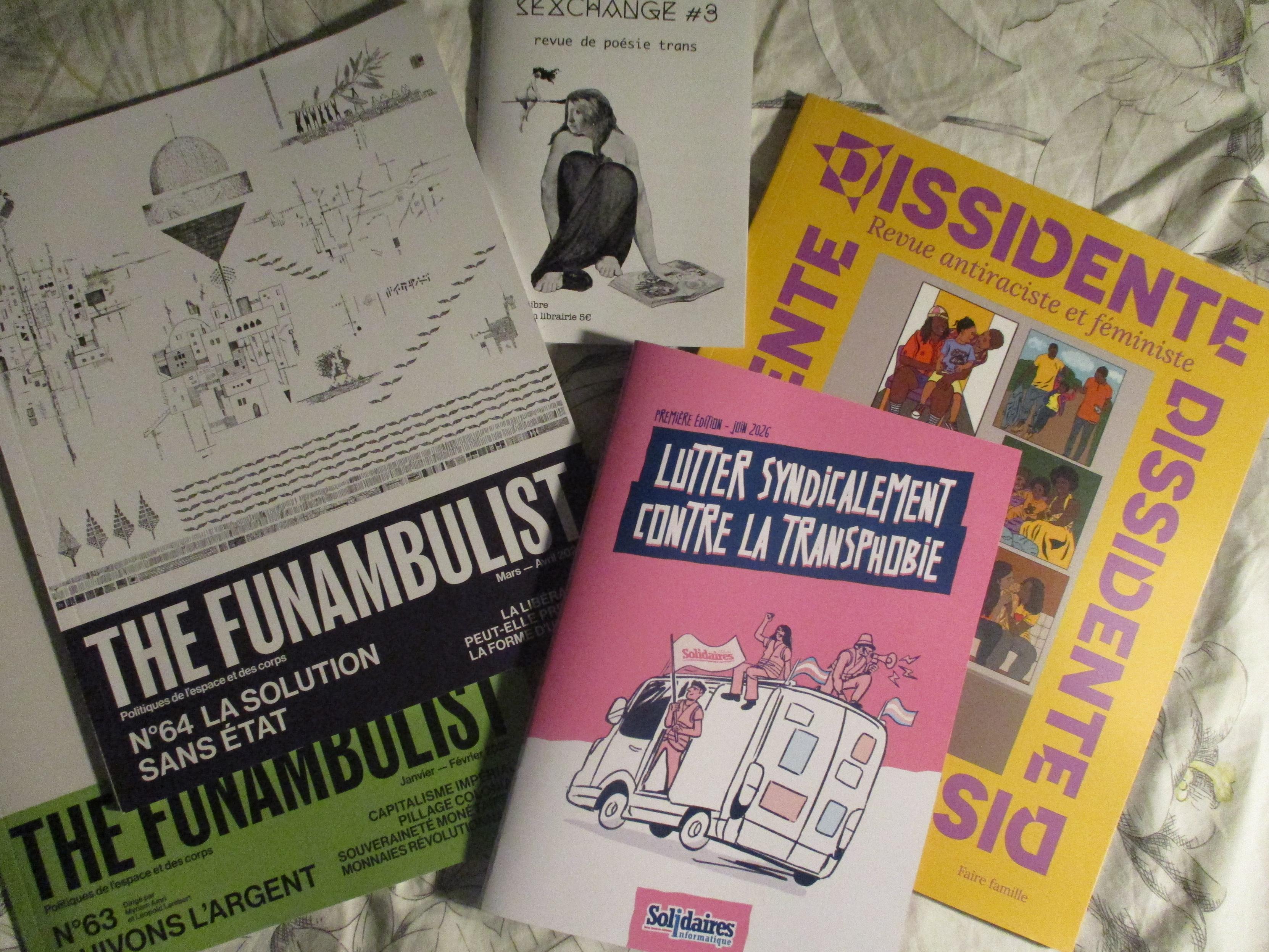 The Funambulist n°64 "La solution sans État" à la couverture blanche et noire sur la gauche, au-dessus du n°63 "Suivons l'argent" au bandeau vert, au centre en rose et bleu la nouvelle brochure Lutter syndicalement contre la transphobie  (1ère édition, juin 2026) de Solidaires Informatique, au dessus un livret blanc de la revue de poésie trans SEXCHANGE #3 et à droite à la couverture mandarine et aux lettrages violet la revue antiraciste et féministe Dissidente n°3 "Faire famille"