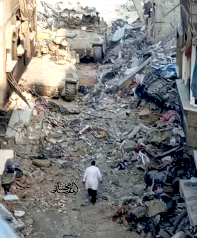 Photo of doctor Hussam Abu Safiya walking while Israel IDF tanks are approaching.